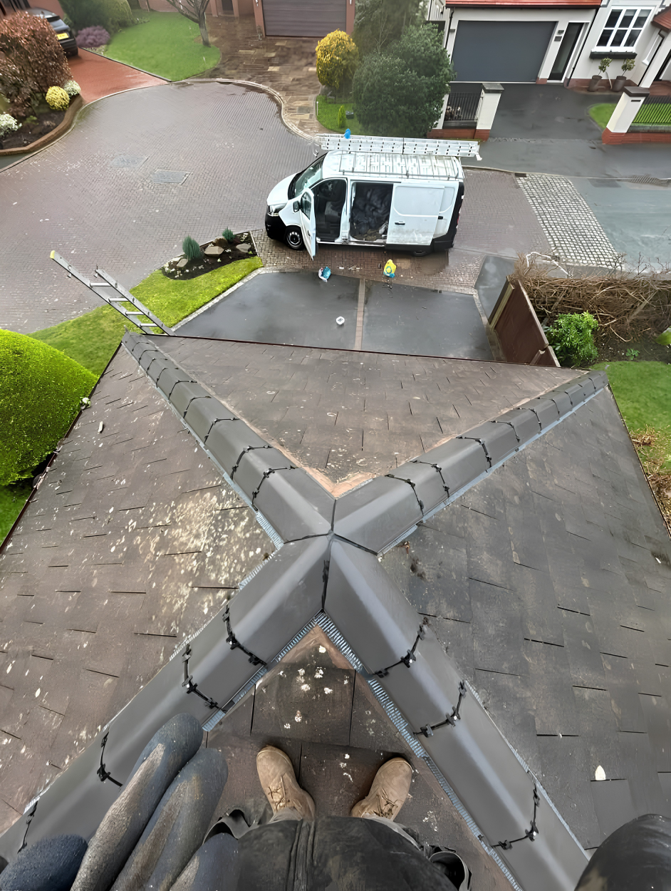 View from a roof being worked on, with the MB Roofline van and ladders on the driveway below