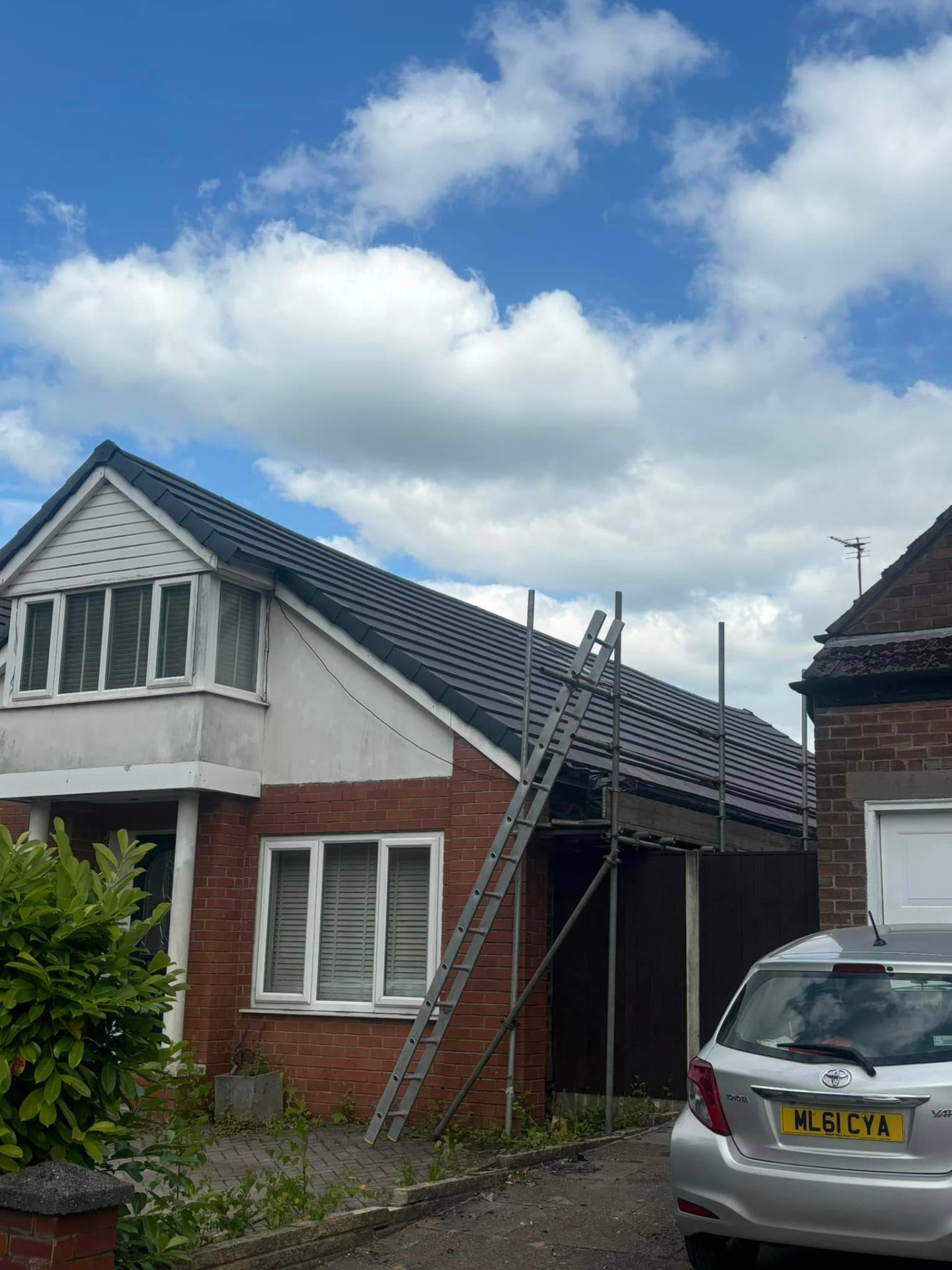 Completed grey tiled re-roof with scaffolding still in place